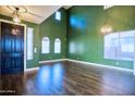 A spacious room with green walls, arched windows, and stylish light fixtures at 35210 N 34Th Ln, Phoenix, AZ 85086