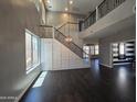 Bright living room boasts high ceilings, dark wood floors, and modern staircase with beautiful metal railings at 35210 N 34Th Ln, Phoenix, AZ 85086