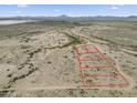 Aerial view of desert land parcel, outlined in red, with mountain backdrop on a sunny day at 385 W Vineyard Rd # C, Tonopah, AZ 85354