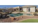Inviting backyard pool area with a built-in bar, rock accents, and desert landscaping at 4243 S Hackberry Trl, Gold Canyon, AZ 85118