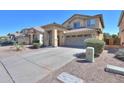 Charming home exterior with a tile roof, two-car garage and desert landscaping on a sunny day at 44115 W Palmen Dr, Maricopa, AZ 85138
