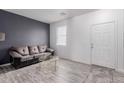 A living room featuring a gray sofa, modern coffee table, and a sleek accent wall at 44165 W Kramer Ln, Maricopa, AZ 85138