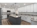 Modern kitchen with white cabinets, granite countertops, a large island, and stainless steel appliances at 4720 E Adobe Dr, Phoenix, AZ 85050