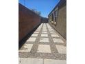 A long and well maintained backyard pathway constructed with stones and gravel at 9302 W Georgia Ave, Glendale, AZ 85305