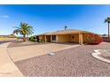 Single-story house with desert landscaping, covered carport, and mature palm trees, offering an appealing exterior at 9746 W Edward Dr, Sun City, AZ 85351