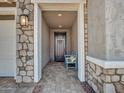 Inviting front porch featuring stone accents, a cozy bench, and a well-lit entryway, perfect for welcoming guests at 9821 E Supernova Dr, Mesa, AZ 85212