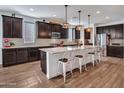 Spacious kitchen featuring dark cabinetry, a large granite island with seating, and modern stainless steel appliances at 9821 E Supernova Dr, Mesa, AZ 85212