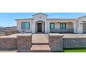 Inviting front exterior with decorative brick walkway, covered porch, and well-maintained landscaping at 10147 W Camino De Oro --, Peoria, AZ 85383