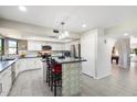 Modern kitchen featuring white cabinets, a center island with seating, and stainless steel appliances at 10800 N 101St St, Scottsdale, AZ 85260