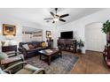 Cozy living room with hardwood floors, a ceiling fan, a leather sofa, and a large window at 11010 E Keats Ave, Mesa, AZ 85209