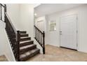 Bright entryway with a staircase and a front door, illuminated by natural light from a window at 11918 W Yearling Ct, Peoria, AZ 85383