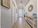 Welcoming hallway featuring tile floors, console table, a decorative mirror, and a modern front door at 12008 S 186Th Dr, Goodyear, AZ 85338