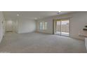 Bright living room featuring plush carpeting, natural light, and access to the outdoor space at 1257 N 166Th Ave, Goodyear, AZ 85338