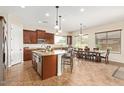 Spacious eat-in kitchen boasts granite countertops, an island, stainless appliances, and tile flooring at 16089 W Harvard St, Goodyear, AZ 85395