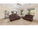 Spacious living room featuring neutral carpet, modern ceiling fan, and lots of natural light at 16089 W Harvard St, Goodyear, AZ 85395
