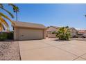 Street view of a single-story home featuring a two-car garage and desert landscaping with a long driveway at 1632 Leisure World --, Mesa, AZ 85206