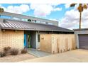 Modern home with a brick accent wall, steel roof, and a bright blue front door at 16920 E Monterey Dr, Fountain Hills, AZ 85268