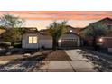 Charming single-story home featuring a tile roof, a two-car garage, and low-maintenance landscaping at 17655 W Tasha Dr, Surprise, AZ 85388