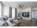 Contemporary living room with a gray sofa, ceiling fan, large mirror, stylish decor, and modern entertainment center at 18250 N Cave Creek Rd # 164, Phoenix, AZ 85032