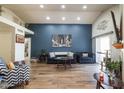 Spacious living room showcasing a blue accent wall, recessed lighting, and wood-look tile flooring at 18435 N 36Th Ave, Glendale, AZ 85308