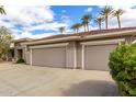 Spacious three-car garage with neutral doors complementing the home's exterior and lush surrounding greenery at 20029 N Coronado Ridge Dr, Surprise, AZ 85387