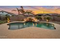 Backyard pool with a rock waterfall feature and lush landscaping, ideal for relaxing evenings at 20102 E Robin Rd, Queen Creek, AZ 85142