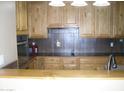 Functional kitchen with light wood cabinetry, tile backsplash, and modern appliances at 2156 W Broadway Ave, Coolidge, AZ 85128