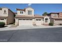 Beige, two story home with two garages, tile roof and desert landscaping at 2600 E Springfield Pl # 59, Chandler, AZ 85286