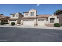 Beige, two story home with two garages, tile roof and desert landscaping at 2600 E Springfield Pl # 59, Chandler, AZ 85286