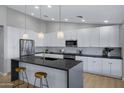 Bright kitchen featuring white cabinets, stainless steel appliances, and a large island with seating at 3060 W Ironwood Cir, Chandler, AZ 85226