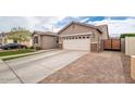 Single-Gathering home with a two-car garage, side yard gate, and concrete driveway at 3121 N Loma Vista Dr, Mesa, AZ 85213