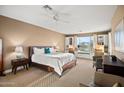 Spacious bedroom featuring dual desks, a king bed, ceiling fan, and bright natural light at 41006 N Noble Hawk Way, Anthem, AZ 85086