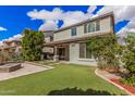 Beautiful backyard featuring an outdoor kitchen and bar, firepit, pergola, well maintained lawn, and lush landscaping at 4281 E Mesquite St, Gilbert, AZ 85296