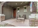 Cozy front porch with chairs and a table, stone columns, and beautiful desert landscaping at 4281 E Mesquite St, Gilbert, AZ 85296