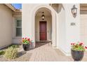 Inviting entrance with a red door, stylish lighting, and potted flowers at 4834 S Meteor --, Mesa, AZ 85212