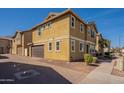 Multi-story home with an attached garage and brick driveway, offering a blend of modern architecture and convenient parking at 504 N Ranger Trl, Gilbert, AZ 85234