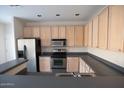 Kitchen featuring stainless steel appliances, light wood cabinets, and dark countertops at 559 E Rainbow Dr, Chandler, AZ 85249