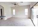 Open living space with neutral carpet, ceiling fan, sliding glass door, and bright, natural light at 559 E Rainbow Dr, Chandler, AZ 85249