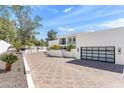 Modern white home with black framed windows, a black garage door, and desert landscaping at 6216 N 38Th Pl, Paradise Valley, AZ 85253