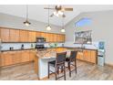 Kitchen with wood cabinetry, granite countertops, stainless steel appliances, and a cozy island with seating at 648 W Cobblestone Dr, Casa Grande, AZ 85122