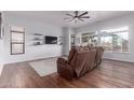 Bright living room with wood floors, a ceiling fan, and large windows at 7235 W Dreyfus Dr, Peoria, AZ 85381