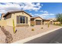 Exterior of home showcasing desert landscaping, tile roof and three car garage at 7630 E Knoll St, Mesa, AZ 85207