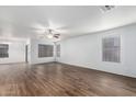 Bright living room with wood-look floors, ceiling fan, neutral walls, and multiple windows with blinds at 8527 E Lindner Ave, Mesa, AZ 85209