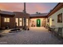 Private courtyard featuring desert landscaping, paved brick, fountain, and a charming green entry door at 8924 E Charter Oak Dr, Scottsdale, AZ 85260