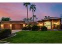 Stunning home with lush green lawn, desert landscaping, and a spacious three car garage at 8924 E Charter Oak Dr, Scottsdale, AZ 85260