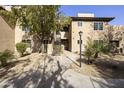 Beautiful condo building featuring a walkway, natural landscaping, and classic desert architecture at 9450 E Becker Ln # 2090, Scottsdale, AZ 85260