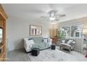 Bright living room showcasing a comfortable sofa, modern ceiling fan, and ample natural light at 1144 N 85Th Pl, Scottsdale, AZ 85257