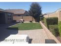 A backyard with a small patch of artificial turf and patio stones at 13812 W Remuda Dr, Peoria, AZ 85383