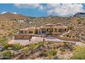 Expansive hillside home featuring a desert landscape, stone accents and clay tile roofing at 14360 E Desert Cove Ave, Scottsdale, AZ 85259