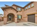 Inviting home with an arched entry, three car garage, and stone accents at 14544 W Sierra St, Surprise, AZ 85379